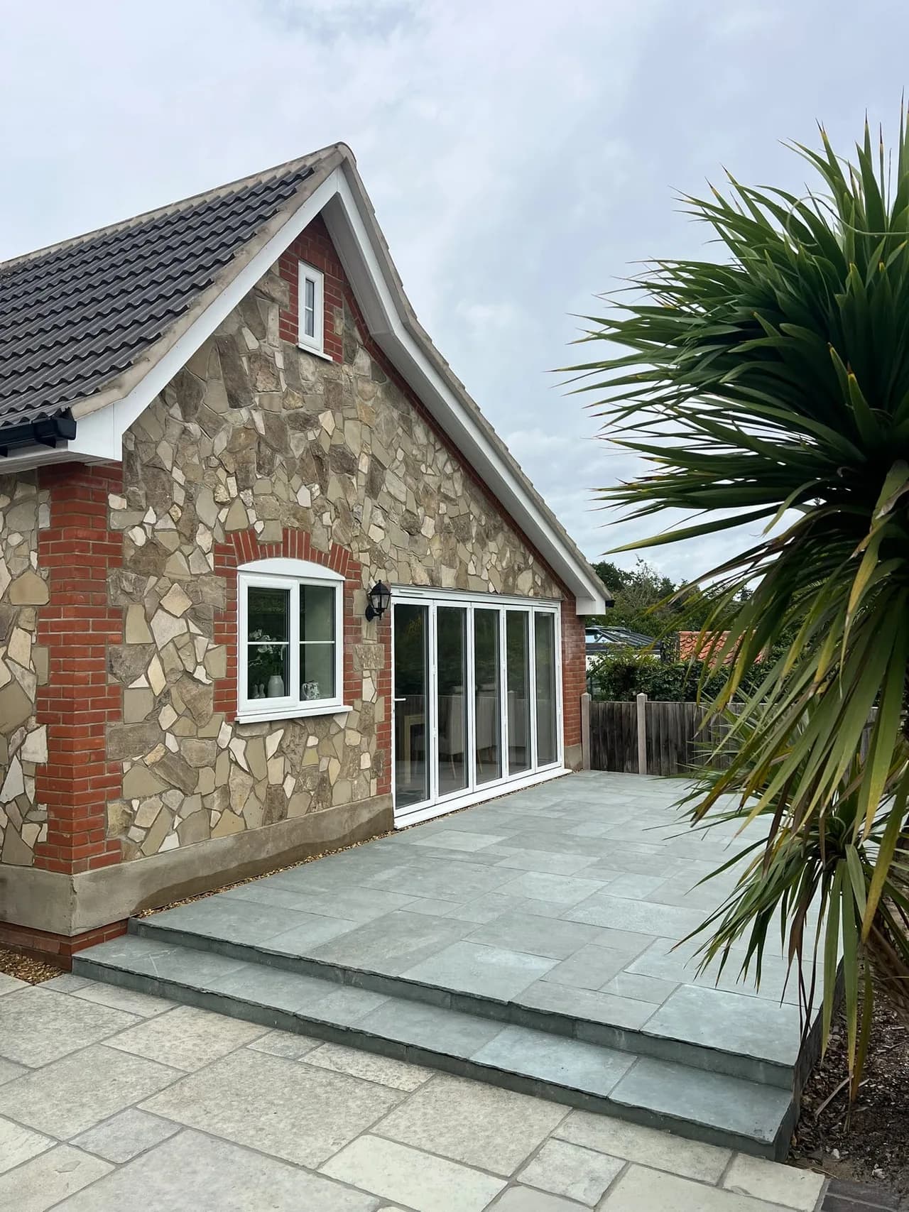 Stone-clad house extension with bifold doors and a newly laid patio