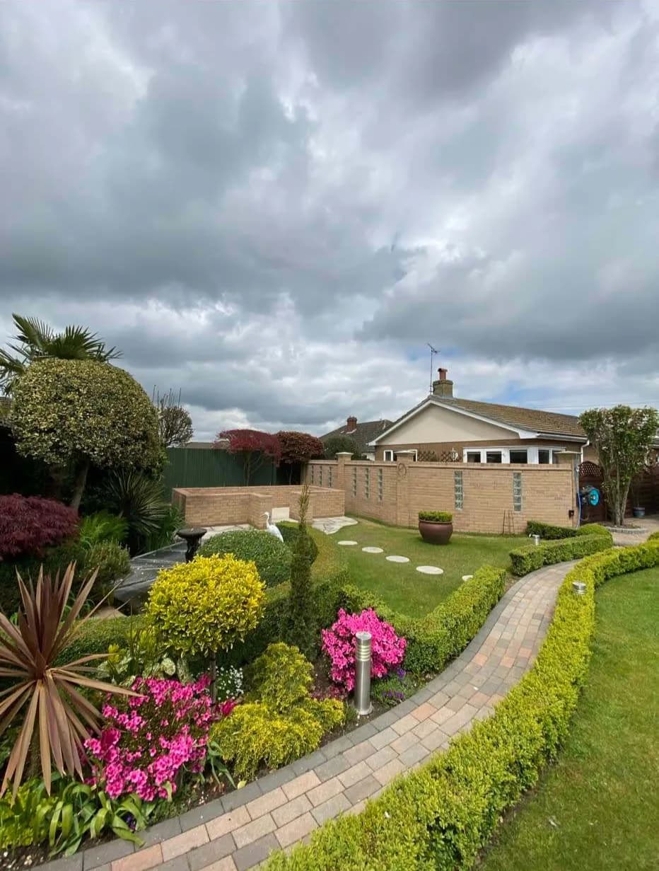 Finished landscaped garden with block-paved path, lawn and planted borders